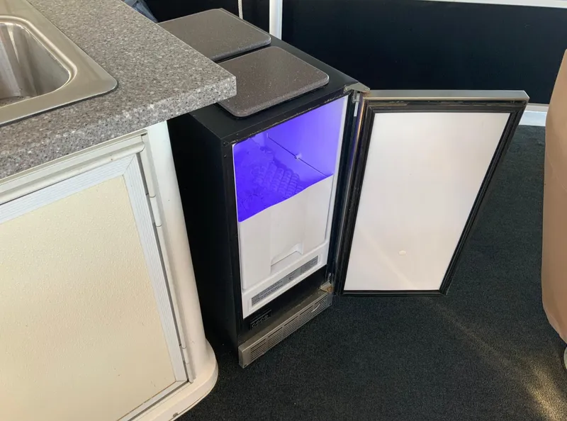 Slide: The Image of Compact refrigerator with open door, blue interior light, next to a countertop on Skipperliner 640. - 16