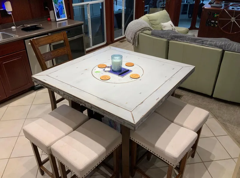 Slide: The Image of Cozy dining area on 2007 Skipperliner 640 with square table and cushioned stools. - 27