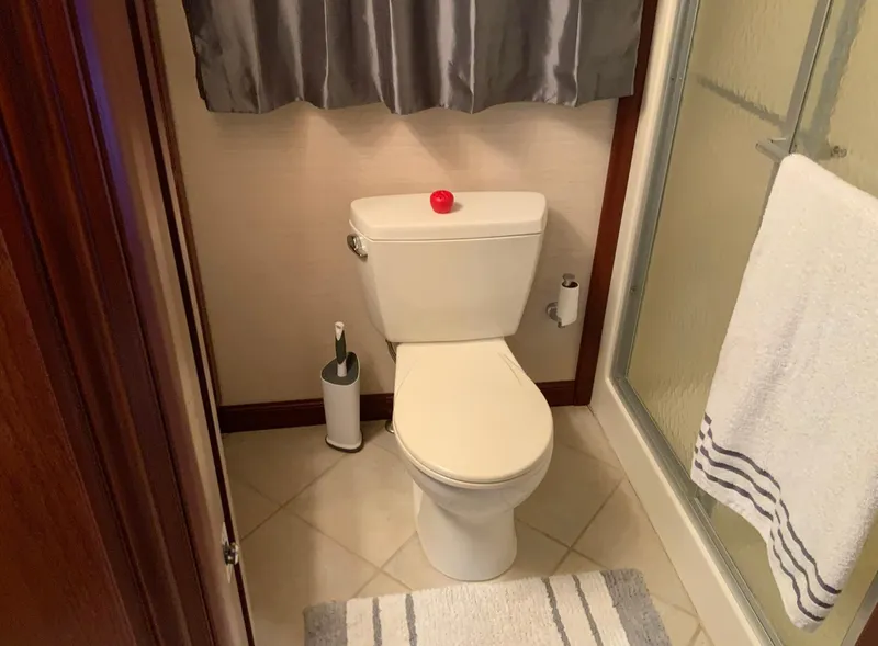 Slide: The Image of Bathroom in 2007 Skipperliner 640 with toilet, shower, and striped rug. - 34
