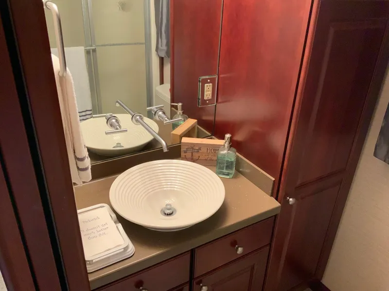 Slide: The Image of Luxurious bathroom in 2007 Skipperliner 640 with modern sink and wooden cabinetry. - 35
