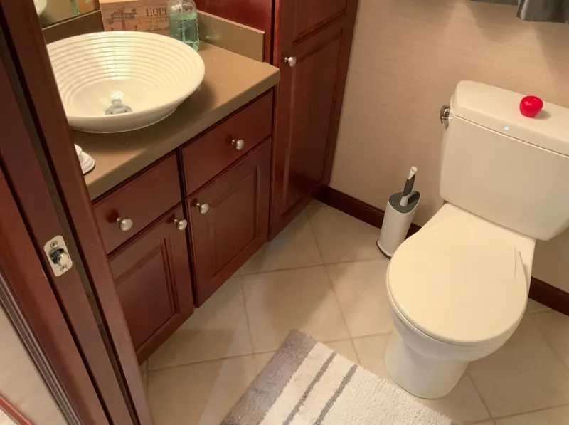Slide: The Image of Bathroom interior of 2007 Skipperliner 640 with sink, toilet, and wooden cabinetry. - 36