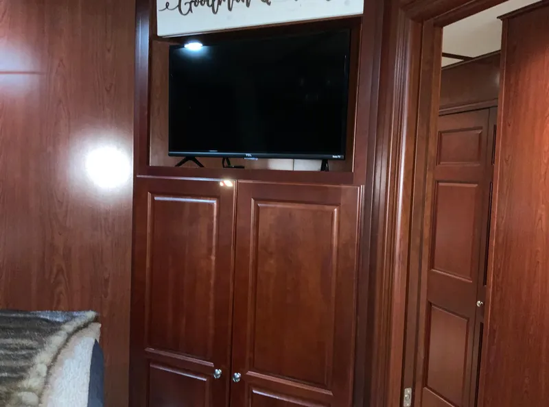 Slide: The Image of Interior of 2007 Skipperliner 640 with wooden cabinets and mounted TV. - 38