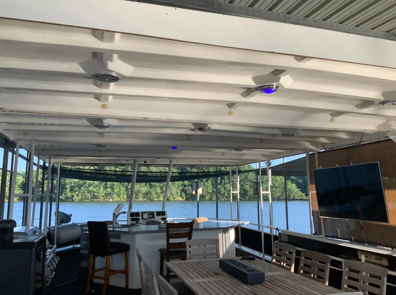 Slide: The Image of 2007 Skipperliner 640 houseboat interior with seating, table, and river view. - 4