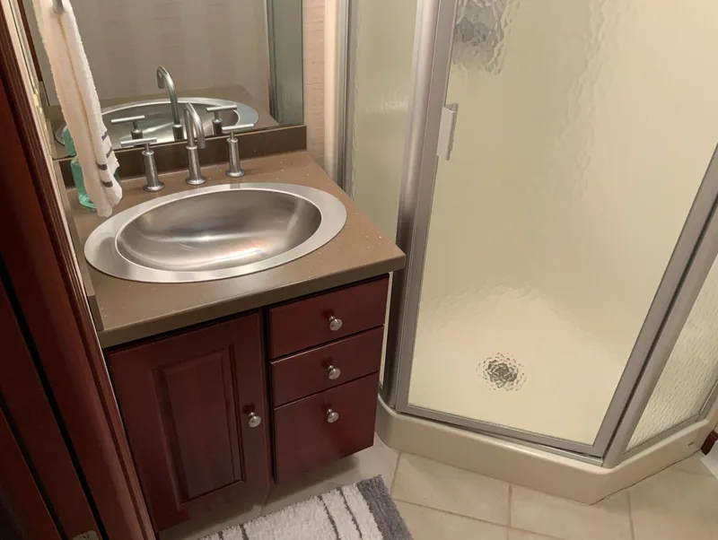 Slide: The Image of Bathroom in 2007 Skipperliner 640 with sink, wooden cabinets, and shower. - 42