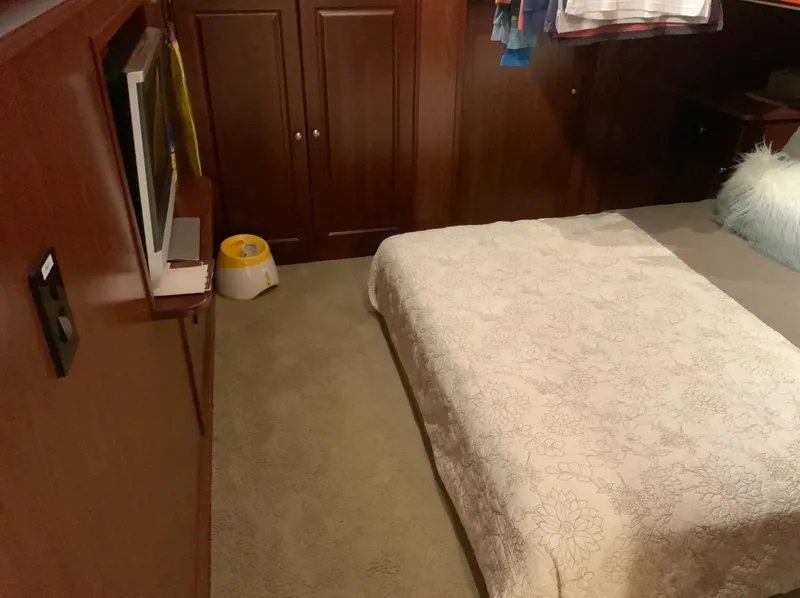 Slide: The Image of Cozy bedroom in 2007 Skipperliner 640 with wooden cabinets and a TV. - 45