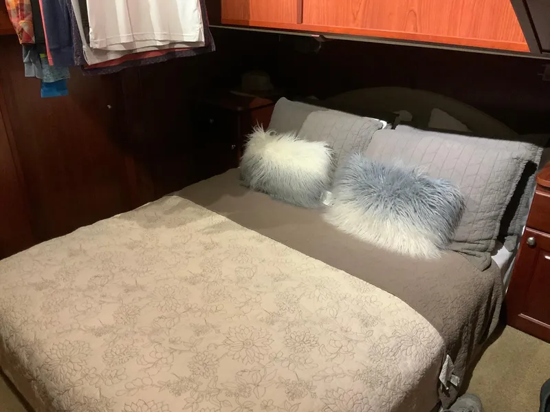 Slide: The Image of Cozy bedroom interior of 2007 Skipperliner 640 with plush pillows and wooden accents. - 46