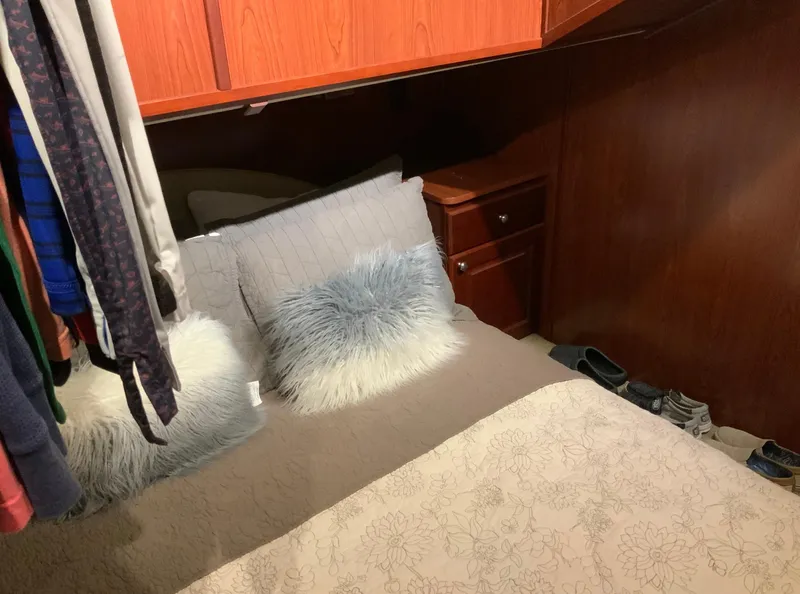 Slide: The Image of Cozy bedroom in 2007 Skipperliner 640 with fluffy pillows and wooden cabinetry. - 47