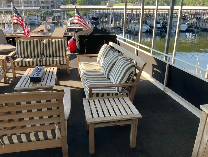 Slide: The Image of Outdoor seating area on 2007 Skipperliner 640 houseboat with striped cushions and lake view. - 5