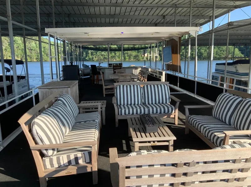 Slide: The Image of 2007 Skipperliner 640 houseboat with striped outdoor seating on a serene lake. - 9