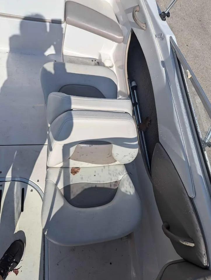 Slide: The Image of 2003 Four Winns Freedom 170 boat interior with white seating and storage compartment. - 12