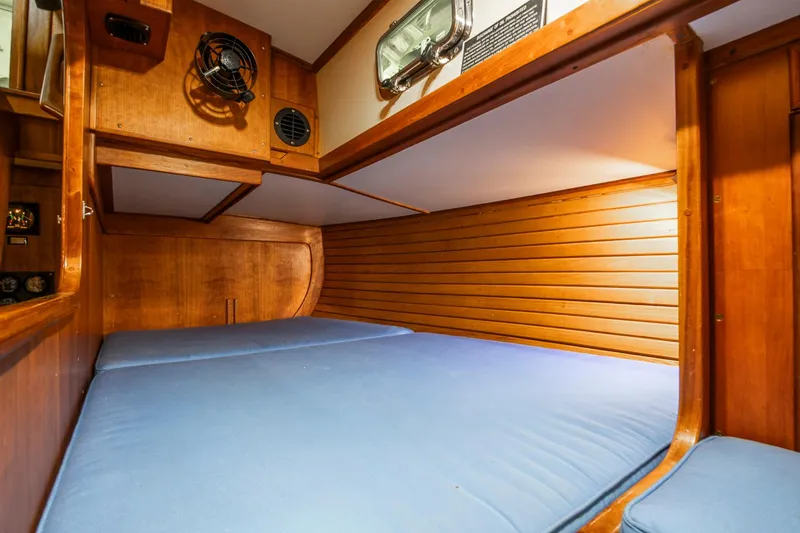 Slide: The Image of Cozy wooden cabin interior with blue bedding on a 1997 Valiant 42 yacht. - 13
