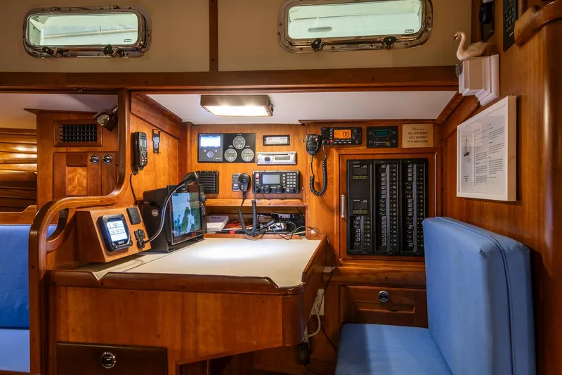 Slide: The Image of Navigation station inside a 1997 Valiant 42 yacht, featuring wooden cabinetry and modern equipment. - 18