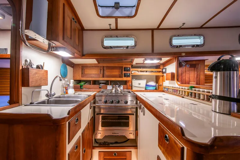 Slide: The Image of Interior of a 1997 Valiant 42 yacht kitchen with wooden cabinetry and modern appliances. - 19