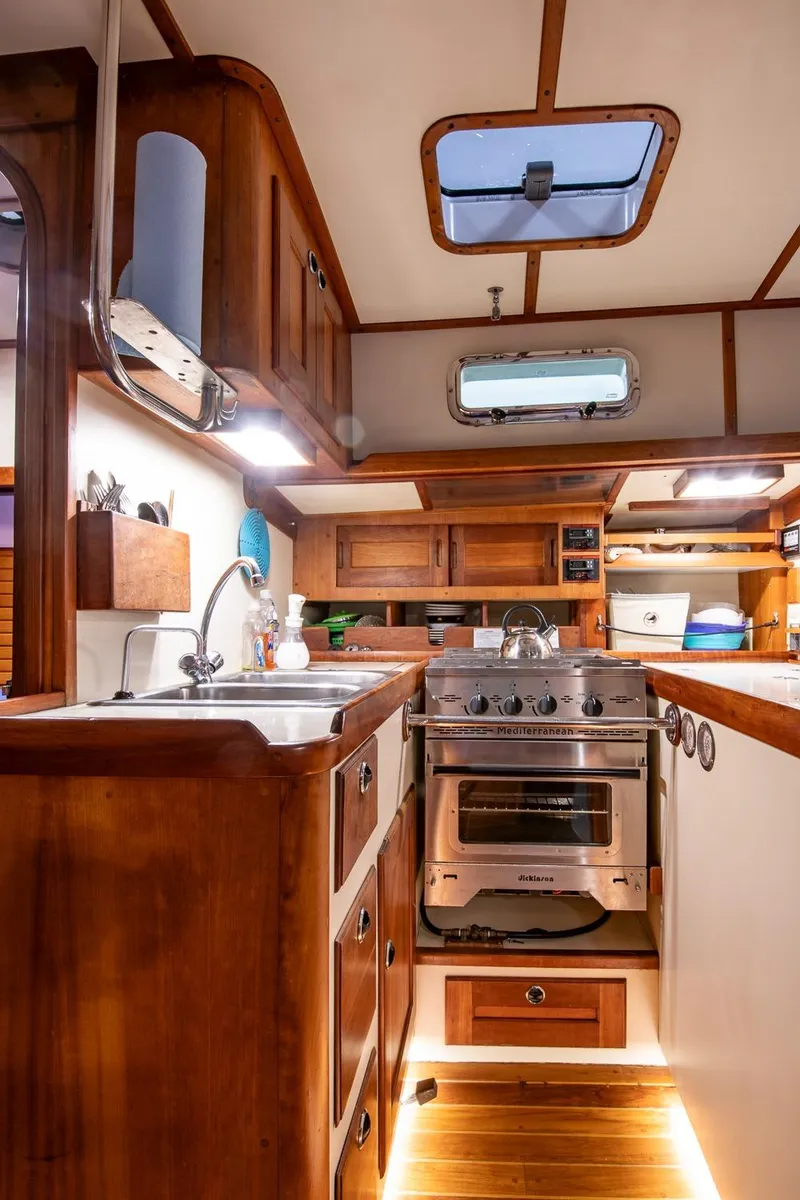 Slide: The Image of 1997 Valiant 42 yacht kitchen with wooden cabinetry, stainless steel oven, and overhead lighting. - 20