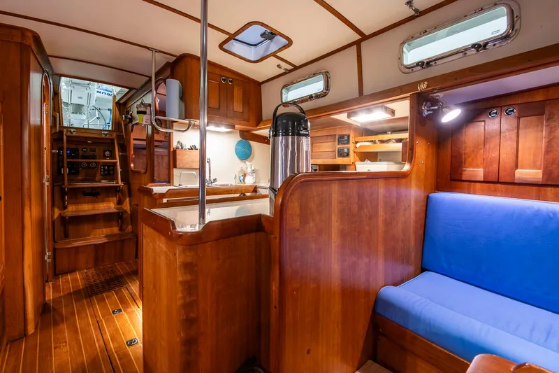 Slide: The Image of Interior of 1997 Valiant 42 sailboat with wooden finish and blue seating. - 21