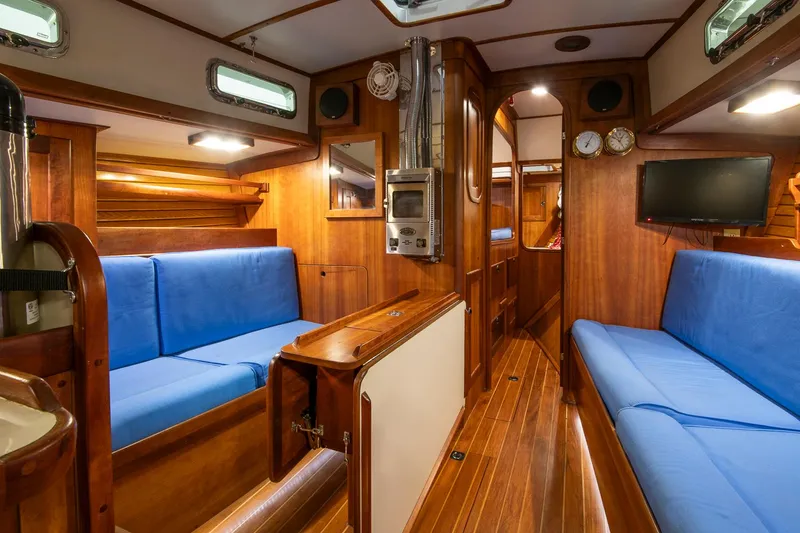 Slide: The Image of Interior of 1997 Valiant 42 sailboat with wooden finish and blue seating. - 23