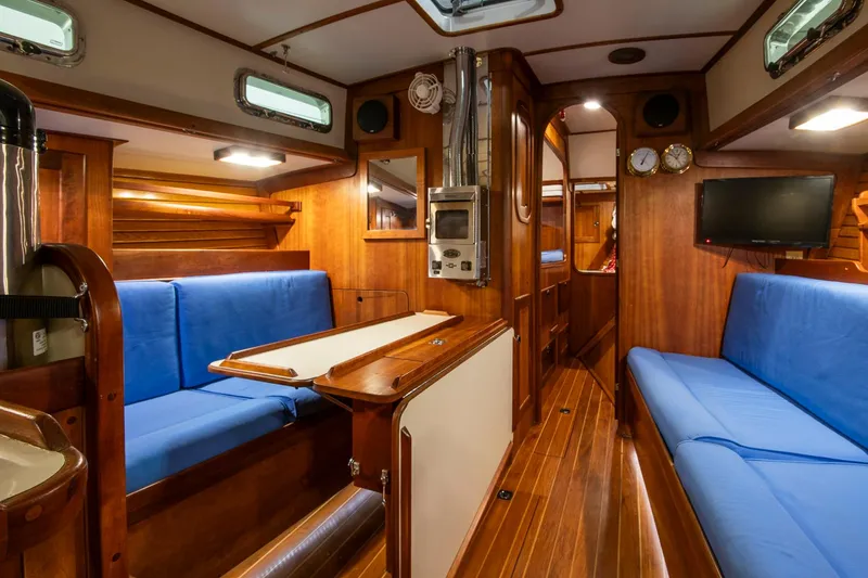 Slide: The Image of Interior of 1997 Valiant 42 sailboat with blue seating and wooden finishes. - 24