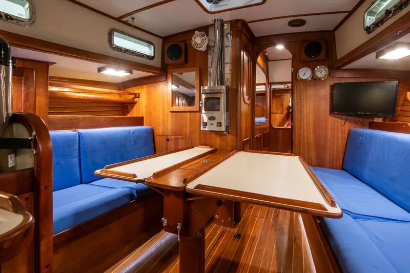Slide: The Image of Interior of 1997 Valiant 42 sailboat with blue seating and wooden finishes. - 25