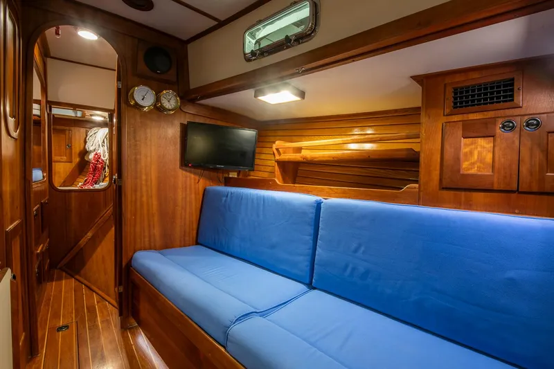 Slide: The Image of Interior of 1997 Valiant 42 yacht with blue seating and wooden paneling. - 26