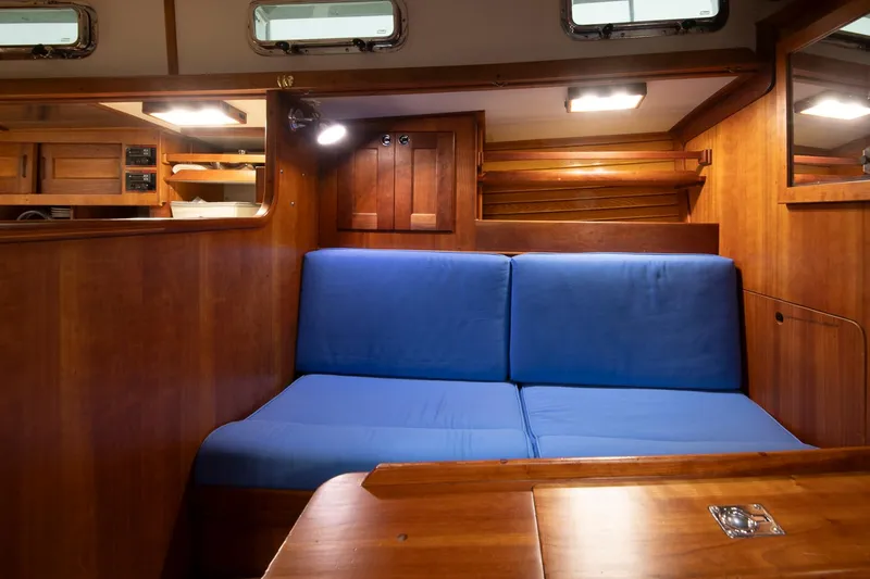 Slide: The Image of Interior of 1997 Valiant 42 yacht with blue cushioned seating and wooden finish. - 27