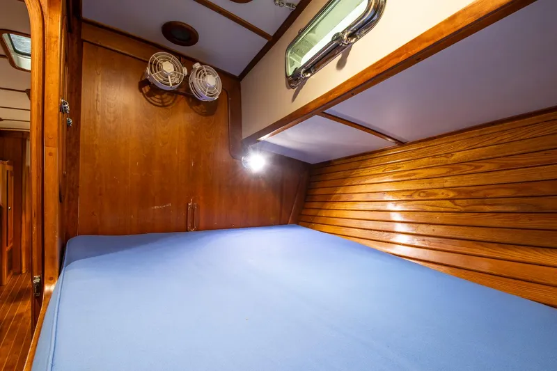 Slide: The Image of Valiant 42 (1997) yacht cabin with wooden interior and blue bedding. - 30