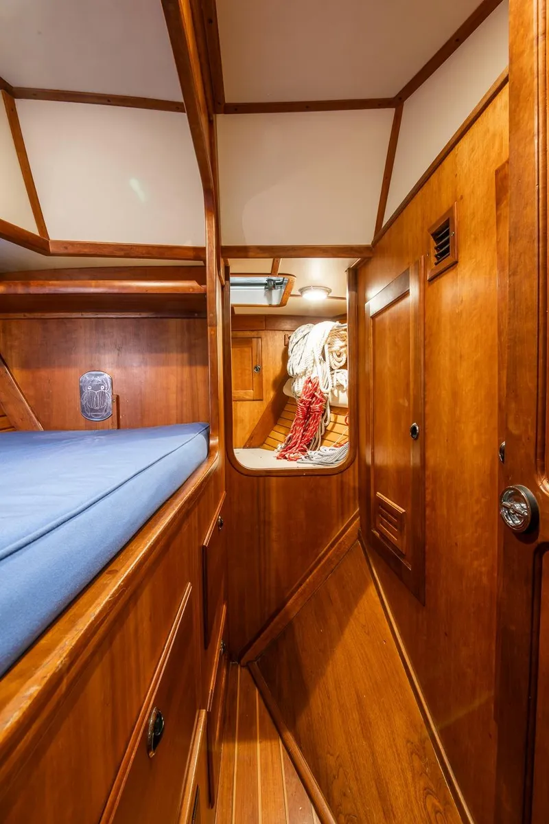 Slide: The Image of Interior of 1997 Valiant 42 sailboat with wooden paneling and blue bedding. - 31