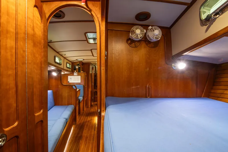 Slide: The Image of Interior of 1997 Valiant 42 sailboat with wooden finish and blue upholstery. - 32