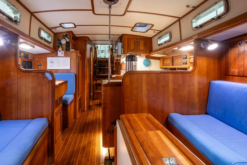 Slide: The Image of Interior of a 1997 Valiant 42 sailboat with wooden finish and blue seating. - 33