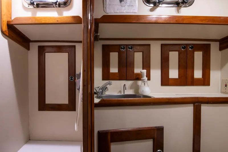 Slide: The Image of 1997 Valiant 42 yacht interior with wooden cabinets and sink. - 35