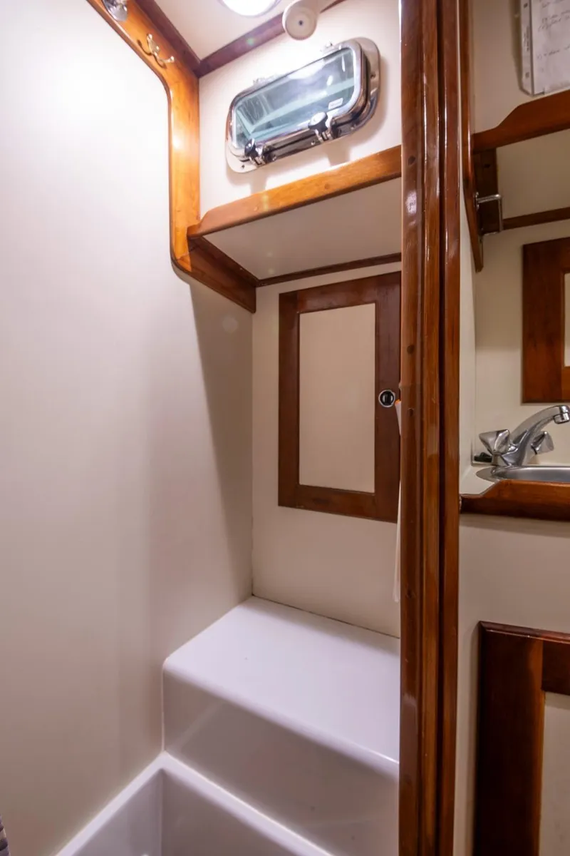 Slide: The Image of Compact bathroom in 1997 Valiant 42 yacht with wooden accents and porthole. - 38
