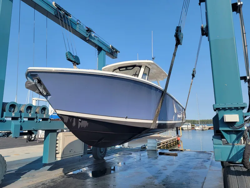 Slide: The Image of 2023 Pursuit S 328 Sport boat being lifted at a marina. - 36