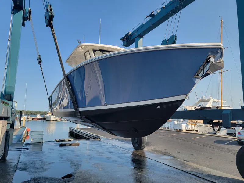 Slide: The Image of 2023 Pursuit S 328 Sport boat being lifted at a marina. - 40