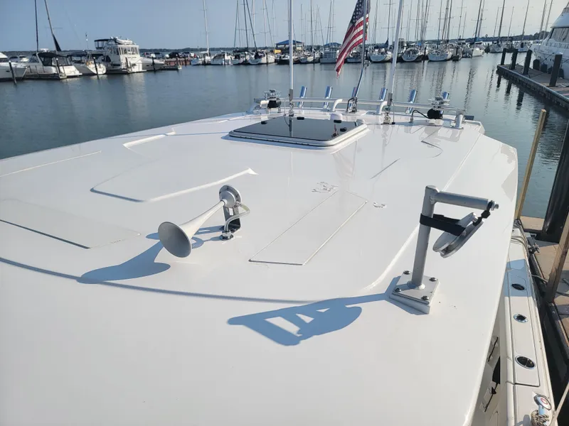 Slide: The Image of 2023 Pursuit S 328 Sport boat docked at marina with American flag. - 44