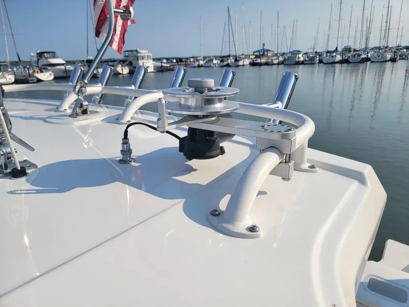 Slide: The Image of 2023 Pursuit S 328 Sport boat deck with rod holders in a marina setting. - 46