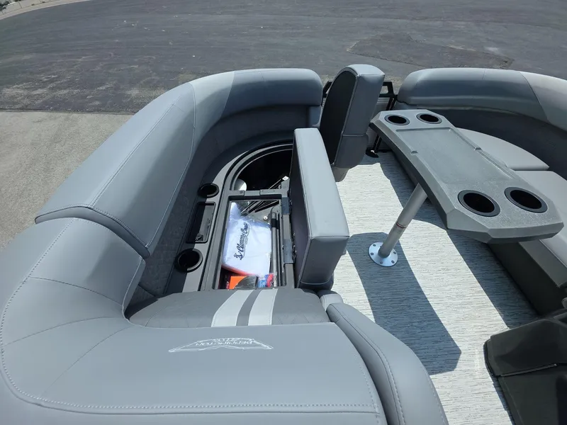 Slide: The Image of 2025 Bennington M Line boat interior with gray seating, storage, and cupholders. - 12