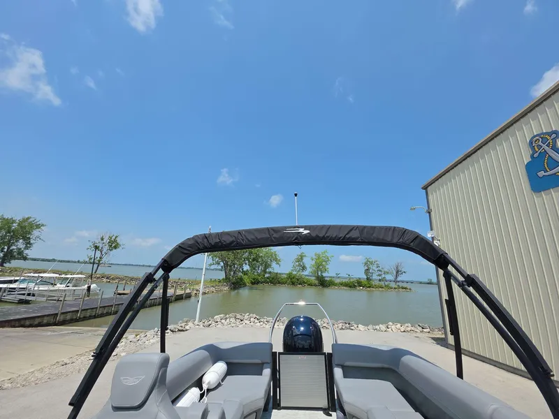 Slide: The Image of 2025 Bennington M Line boat docked by a serene lake under a clear blue sky. - 19