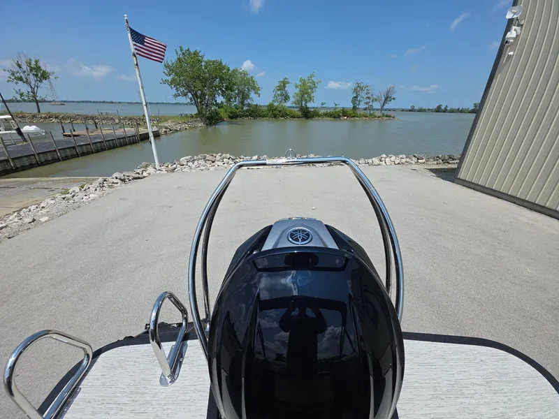 Slide: The Image of 2025 Bennington M Line boat at dock, American flag, lake view, clear sky. - 20