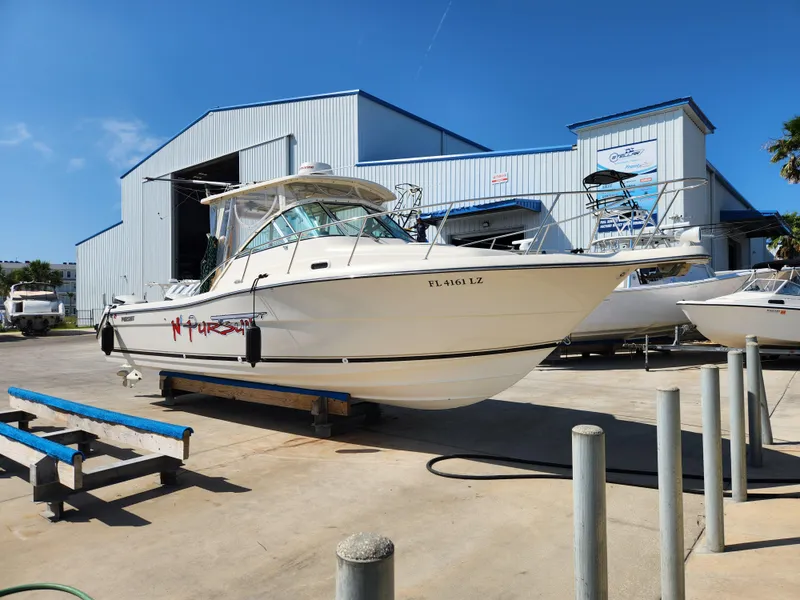 The Image of 2005 Pursuit 3070 Offshore Center Console boat on display at a marina. - 1