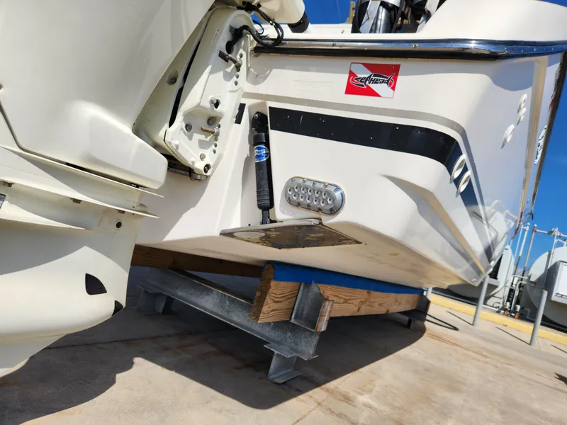 Slide: The Image of 2005 Pursuit 3070 Offshore Center Console boat on trailer, rear view, showing motor and hull details. - 12