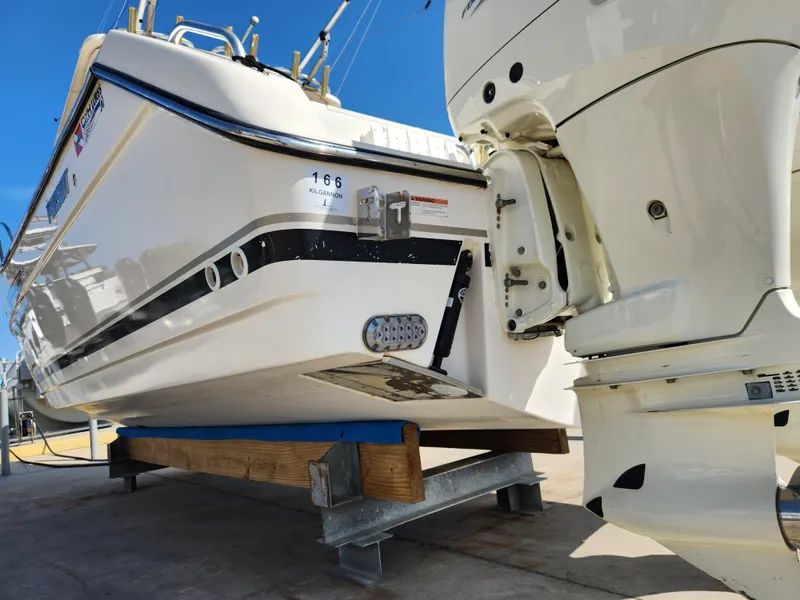 Slide: The Image of 2005 Pursuit 3070 Offshore Center Console boat on a stand, rear view with outboard motor. - 13