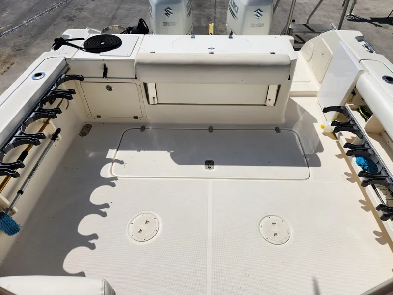 Slide: The Image of 2005 Pursuit 3070 Offshore Center Console boat deck with rod holders and storage compartments. - 25
