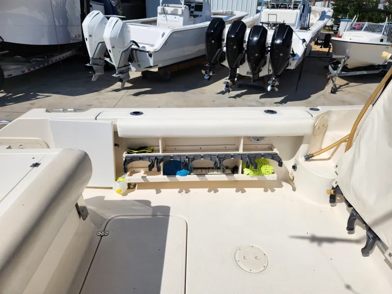 Slide: The Image of 2005 Pursuit 3070 Offshore Center Console boat with open storage compartment and multiple outboard engines. - 27