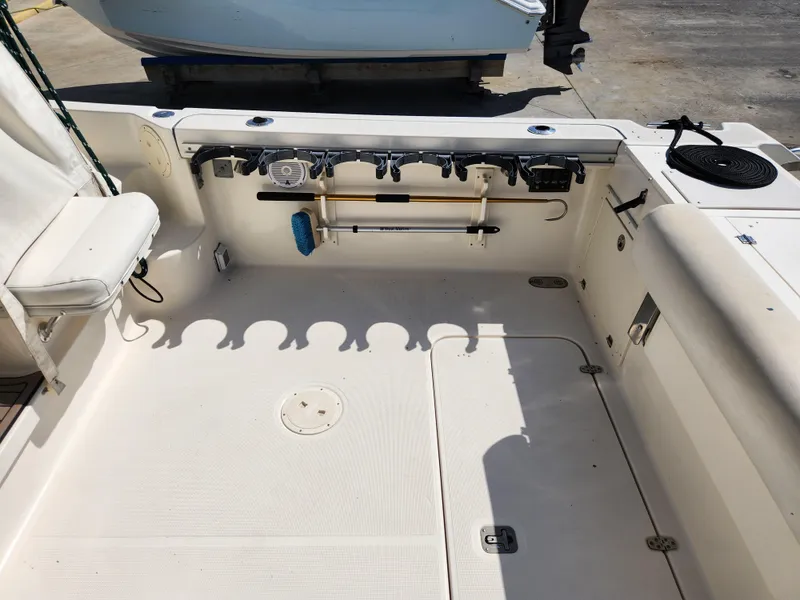 Slide: The Image of 2005 Pursuit 3070 Offshore Center Console boat deck with rod holders and seating. - 28