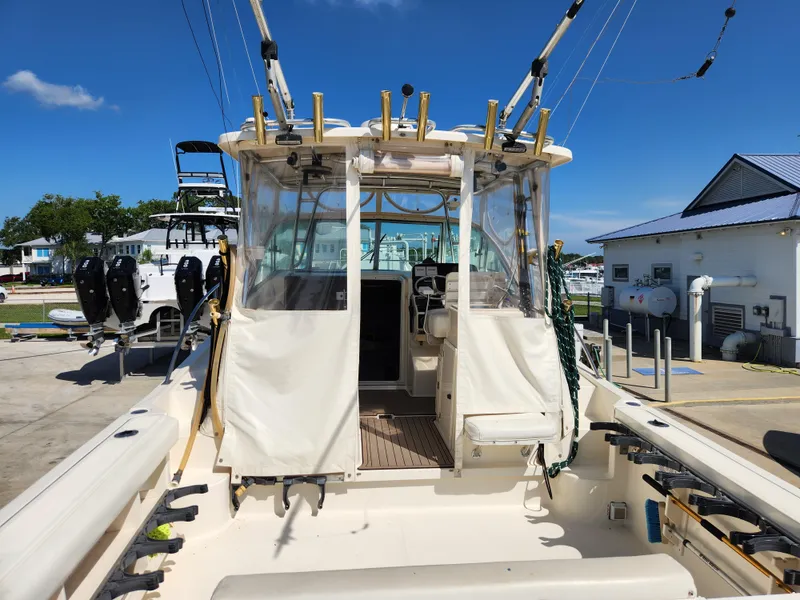 Slide: The Image of 2005 Pursuit 3070 Offshore Center Console boat docked under clear blue sky. - 32