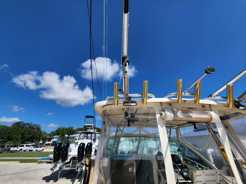 Slide: The Image of 2005 Pursuit 3070 Offshore Center Console boat under clear blue sky. - 34
