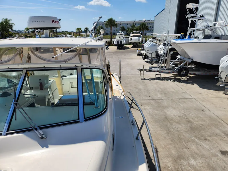 Slide: The Image of 2005 Pursuit 3070 Offshore Center Console boat in a marina with other vessels. - 40