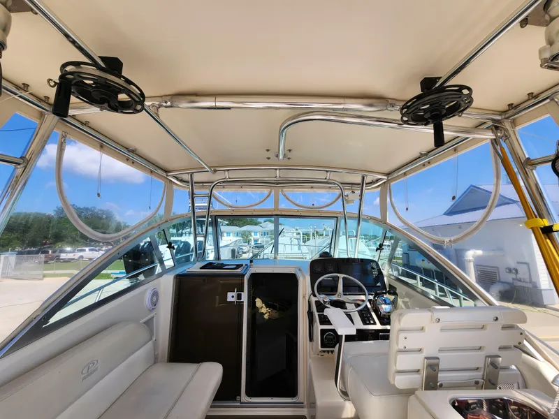 Slide: The Image of 2005 Pursuit 3070 Offshore Center Console interior with helm, seating, and storage compartments. - 43