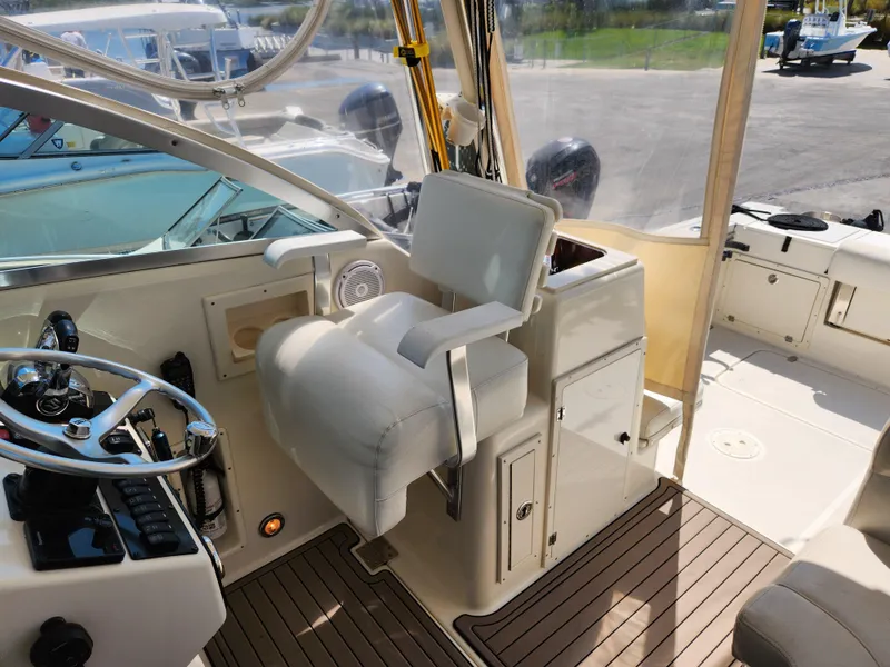 Slide: The Image of 2005 Pursuit 3070 Offshore Center Console boat interior with helm and seating area. - 45