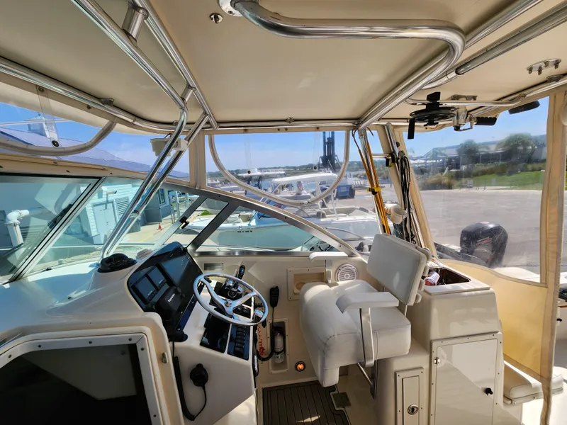 Slide: The Image of 2005 Pursuit 3070 Offshore Center Console interior with helm, seating, and controls. - 47