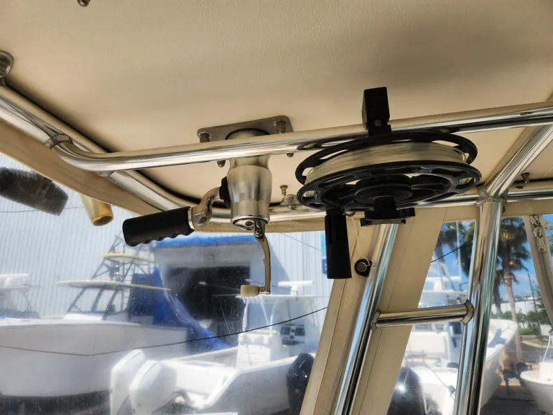 Slide: The Image of 2005 Pursuit 3070 Offshore Center Console interior with fishing rod holder and reel. - 49